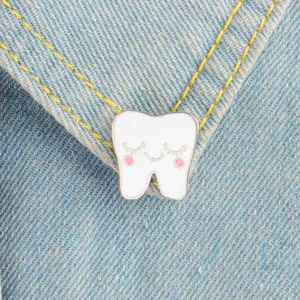 Cartoon tooth enamel pin with a smiling face pinned on blue denim jacket pocket
