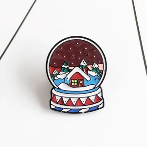 Enamel snowflake crystal ball brooch with a red house and festive winter scene