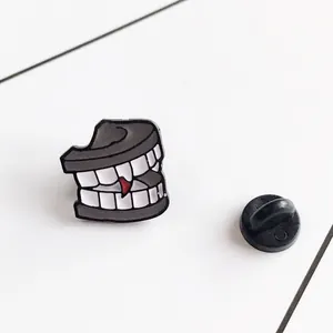 Cartoon vampire teeth enamel pin with red blood drops and black rubber clutch backing