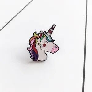 Detailed view of cartoon unicorn enamel brooch with vibrant rainbow colors and metal base