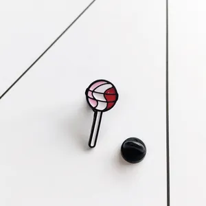 Lollipop enamel brooch with pink and red swirl pattern and black rubber back pin