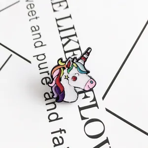 Close-up of a cartoon unicorn enamel pin with rainbow hair and sparkling white finish