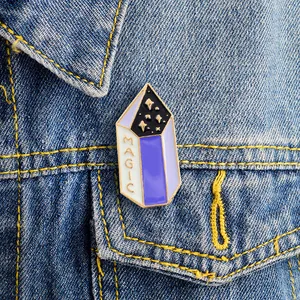 Détail du pin's émaillé cristal magique avec lettres dorées sur une veste en jean
