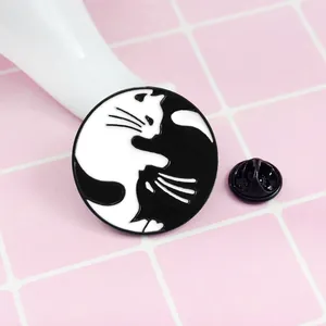 Vue macro d'un pin's en émail Yin Yang chats noir et blanc avec fermoir papillon au dos