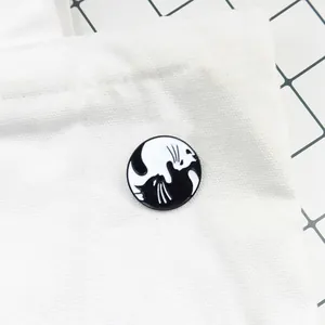 Détail du pin's émaillé chats yin yang noir et blanc sur un sac en toile blanc