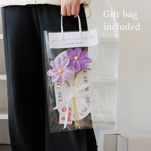 Handgebreide paarse cosmos bloemen in transparante geschenktas met wit sierlint