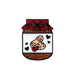 Detailed macro of enamel jar pin featuring a red bow lid and brown glitter filling