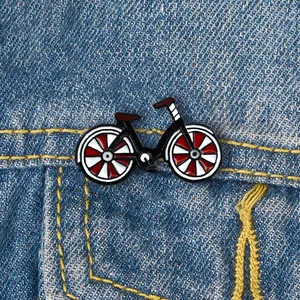 Mini Emaille Fahrrad Anstecknadel mit roten Akzenten auf blauer Jeansjacke