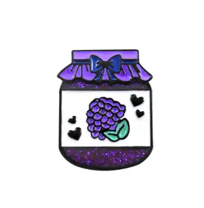 Detail of purple grape jam bottle enamel pin with blue bow and glittery finish