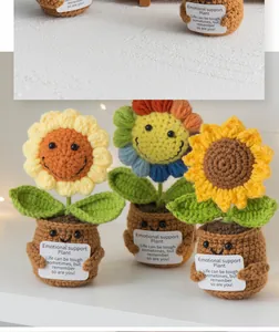 Close-up of handmade crochet sunflower pots with smiling faces and cute greeting cards