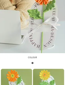Macro detail of hand-knitted orange gerbera flower bouquet on white decorative card