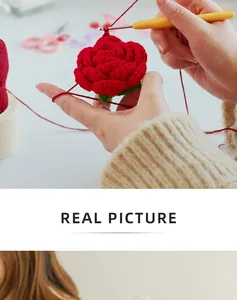 Detailed close-up of handmade crochet red rose being crafted with yarn and hook