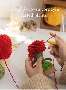 Detailed close-up of handmade crochet red carnation flower being crafted with a needle