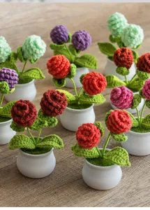 Detailed close-up of handmade crochet mini potted plants with colorful knitted flowers