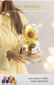 Close-up of handmade crochet sunflower in glass dome with warm bokeh lighting