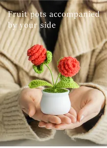 Close-up of handmade crochet pinecone flowers in a white ceramic pot held by hands