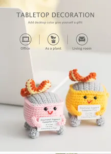 Detail of hand-knitted dumpster fire plushies in pink and yellow with mood cards