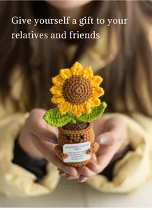 Close-up of a handmade crochet sunflower with a smiley face holding an encouragement card