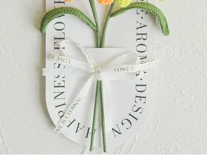 Detail van handgemaakte gehaakte tulp met luxe wit lint en decoratieve geschenkkaart
