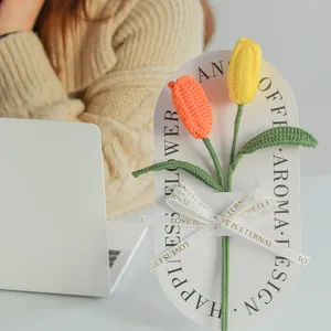 Handmade crochet tulips in yellow and orange tones with decorative ribbon wrap