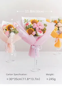 Tres ramos de flores de ganchillo hechos a mano con girasol y rosa en un soporte