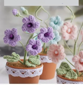 Close-up of handmade crochet freesia bonsai with purple flowers and lace decorated pot