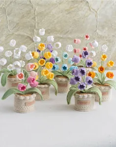 Detail of handcrafted crochet lily of the valley potted flowers in multiple colors