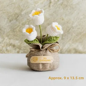 Detail of handcrafted crochet lily of the valley in a rustic burlap bag, size 9x13.5cm