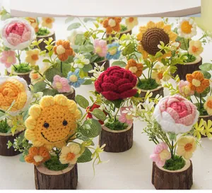Detailed knit texture of handmade crochet potted sunflower and assorted flowers on wood