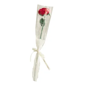 Handmade knitted red rose flower in a gift bag with love ribbon for Valentine's Day