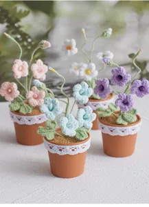Detailed close-up of four handmade crochet potted freesia flowers with delicate lace decor