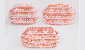Dettaglio di tre pochette a nuvola lavorate a mano con trama in cotone rosa e arancione