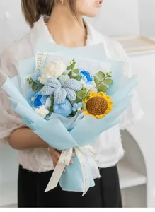 Ramo de flores de ganchillo hecho a mano con girasoles y rosas sostenido por persona