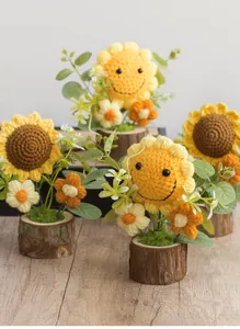 Detail of handmade crochet sunflower pot with smiley face and natural wood base decor
