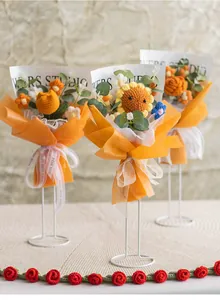 Macro detail of handmade crochet flower bouquet with orange wrap and textured yarn petals