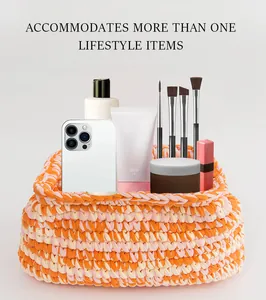 Dettaglio della borsa cosmetica in cotone intrecciato arancione e crema con accessori