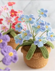 Detailed view of handmade crochet blue forget-me-not flower pot in soft wool