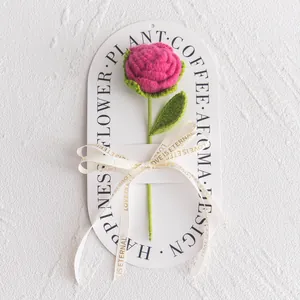 Detailed view of hand-knitted rose on display card with Love Is Eternal ribbon decoration