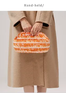 Vista a mano di una pochette colorata in cotone intrecciato a mano con motivi a righe