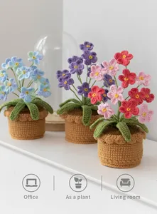 Detailed view of handmade crochet forget-me-not flower pots in blue, purple and pink
