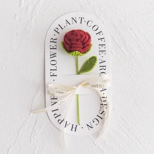 Detailed handmade crochet red rose on decorative gift card with beige love ribbon