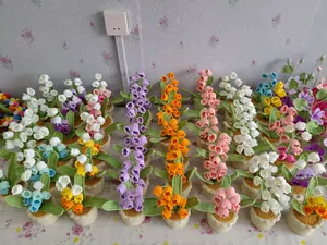 Detail of colorful handmade crochet lily of the valley potted plants in multiple colors