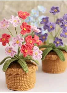 Detail of handmade crochet forget-me-not flowers in pink and blue knitted pots
