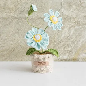 Handmade crochet light blue daisy potted plant with green leaves and a leather tag