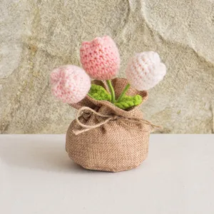 Détail de tulipes roses faites à la main au crochet dans un pot en toile de jute