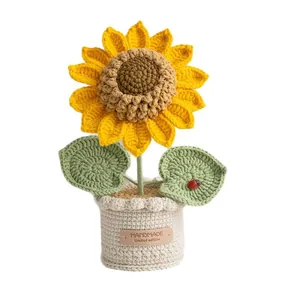 Handmade knitted sunflower potted plant ornament with a handmade leather tag on a beige base