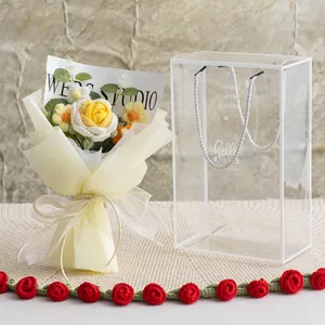 Handgehäkelter Blumenstrauß mit Rosen und Gänseblümchen in gelber Geschenkverpackung