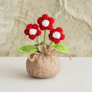 Handmade crochet red and white puff flower potted plant with burlap bag base decor