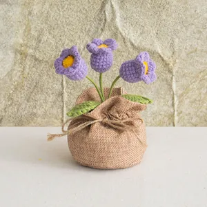 Detail of handmade crochet purple lily flowers in rustic burlap pot for home decor