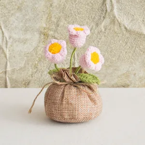 Detail of handmade crochet pink lily of the valley in rustic burlap sack pot